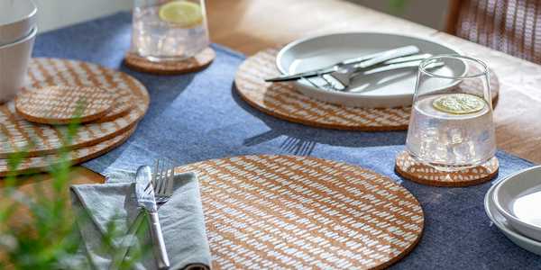 Cork placemats and coasters on a blue table runner.